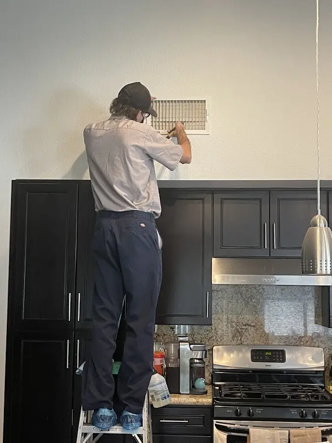 Technician inspecting an air vent during HVAC service in Waimalu